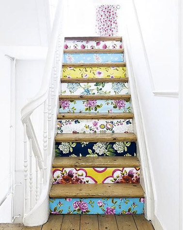 Les murs blancs font un joli contraste avec les contremarches qui ont été décorées de papier peint ! Des motifs colorés et fleuries pour un escalier pétillant 