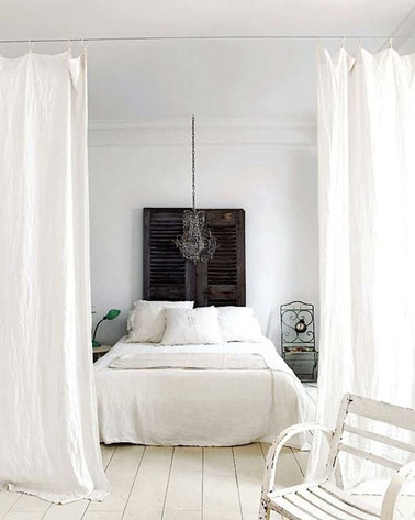 Cette chambre blanche ultra originale adopte la déco récup pour une ambiance chic et élégante ! Des voilages complètent la déco ainsi qu'une tête de lit faite avec des volets 