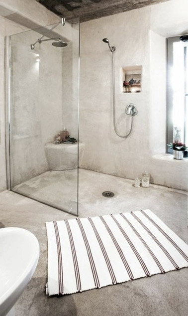 Relaxation assurée dans cette salle de bain lumineuse en béton ciré beige ultra chic ! Une salle de bain déco accueillant une douche italienne pleine d'élégance 