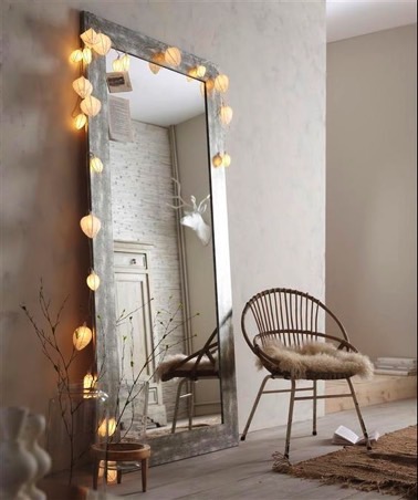 Encadré d'une guirlande lumineuse, ce long miroir vertical en bois vieillit apporte une ambiance scintillante et complète la déco d'inspiration scandinave 