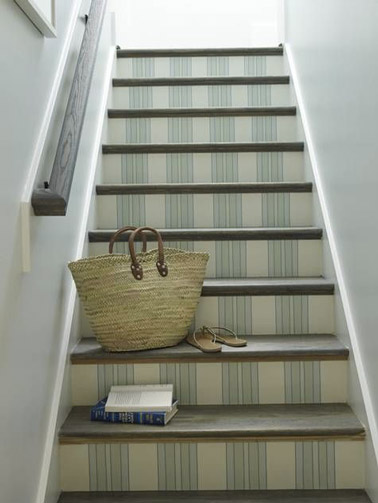 Une déco douce et apaisante dans les escaliers de la maison aux murs blancs avec du papier peint beige et vert pastel à motifs posé sur les contremarches !