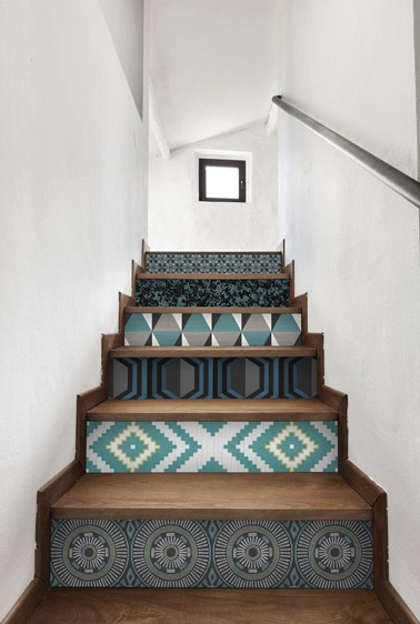 Dans un escalier sobre, rien de mieux que de relever la déco avec du papier peint sur les contremarches ! Ici les motifs géométriques colorés sont à l'honneur !