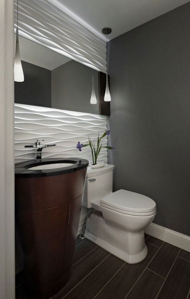 On mise sur une déco design dans la salle de bain avec un mariage de blanc et de gris anthracite mis en valeur par deux suspensions lumineuses ultra chic 