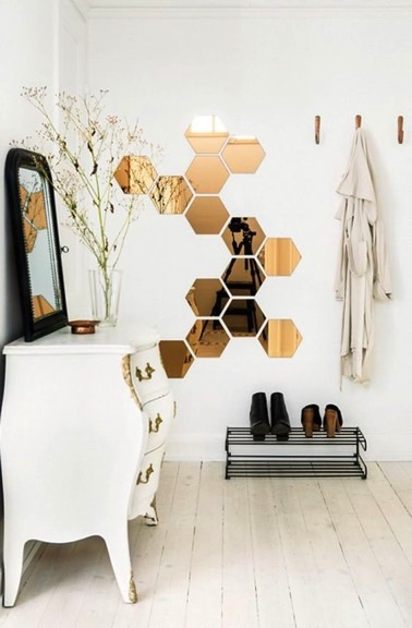 Voilà une bonne idée pour habiller le hall d'entrée ! Des miroirs de formes hexagonales placés sur le mur donnent du style à ce petit espace accueillant
