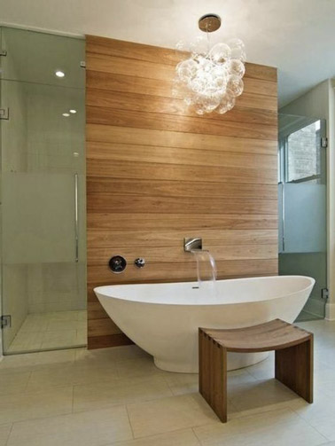 Comme un petit espace spa relaxant, cette baignoire îlot ovale trouve sa place dans la salle de bain en bois et la sublime pour des moments de tranquillité ! 