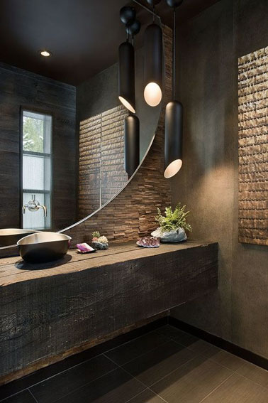 Relaxation et détente assurée dans cette salle de bain marron et bois zen décorée de deux suspensions lumineuses noires en forme de tubes ultra originales ! 