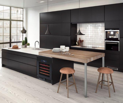 meubles de cuisine peints en noir en contraste avec un plan de travail et une crédences blancs et une table bar en bois